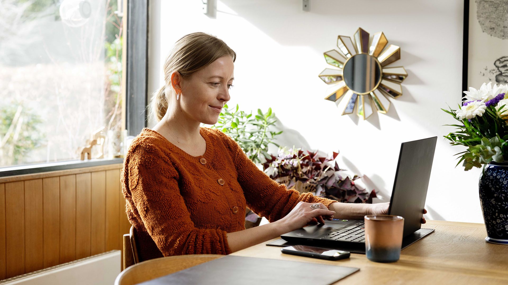 Kvinde sidder foran computeren og tilpasser sine forsikringer.