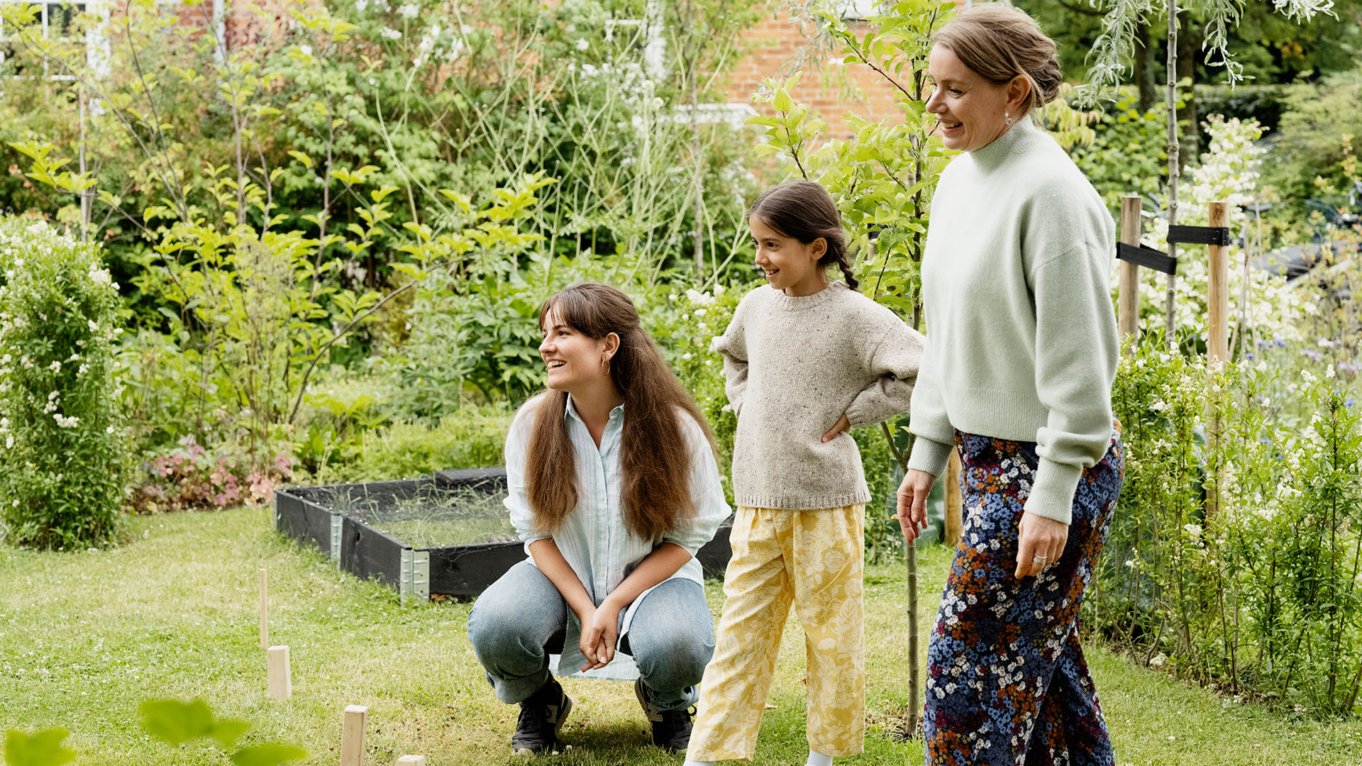 Familie spiller spil i haven, hvor ulykkesforsikringen dækker familien og indboforsikringen dækker deres ting.