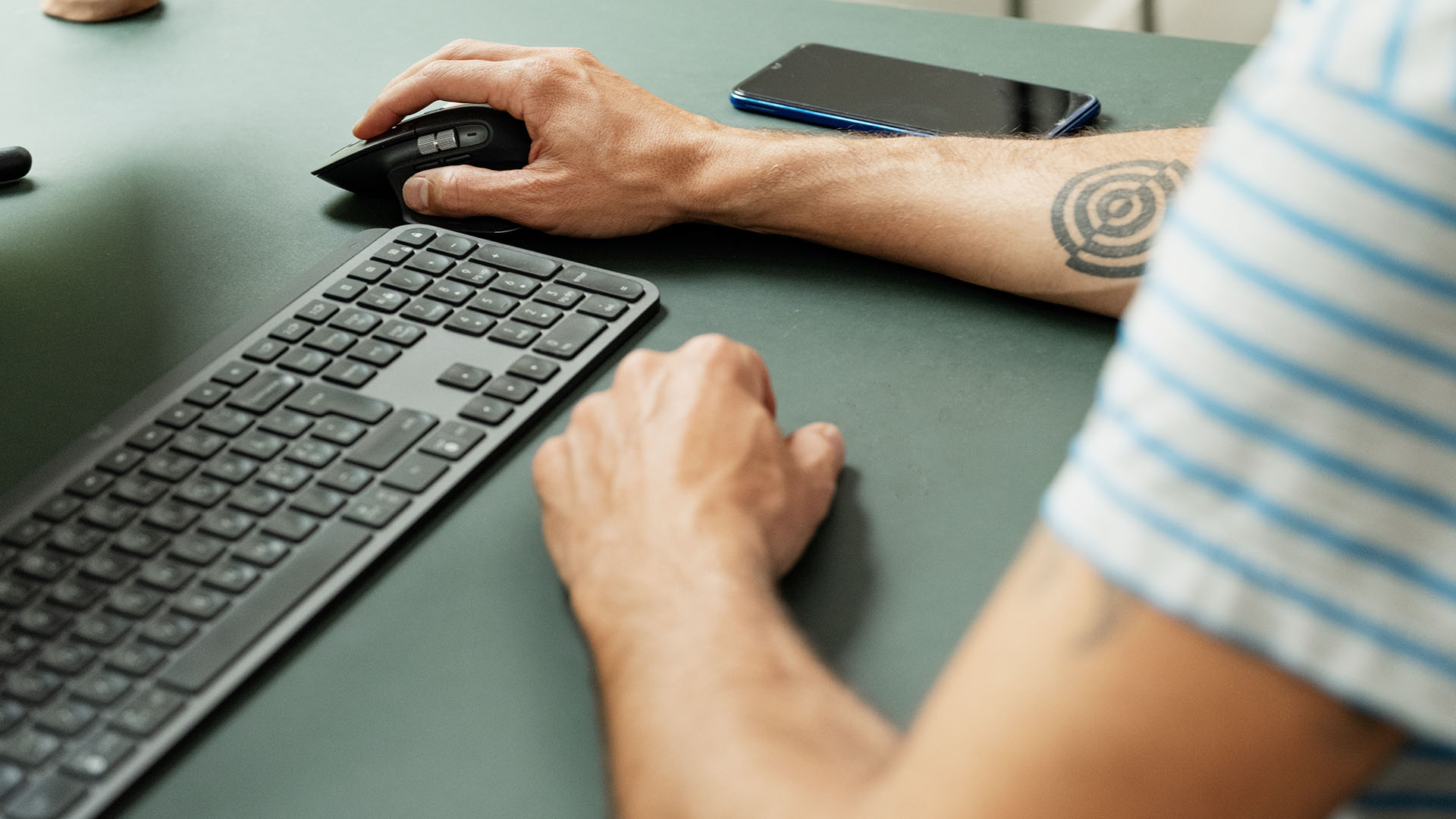 Mand sidder foran computeren, som indboforsikringen dækker. 